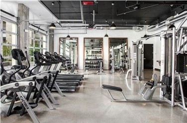 Full view glass door in a home gym with treadmills and weights