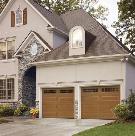 Traditional steel garage doors with window panels on a modern home